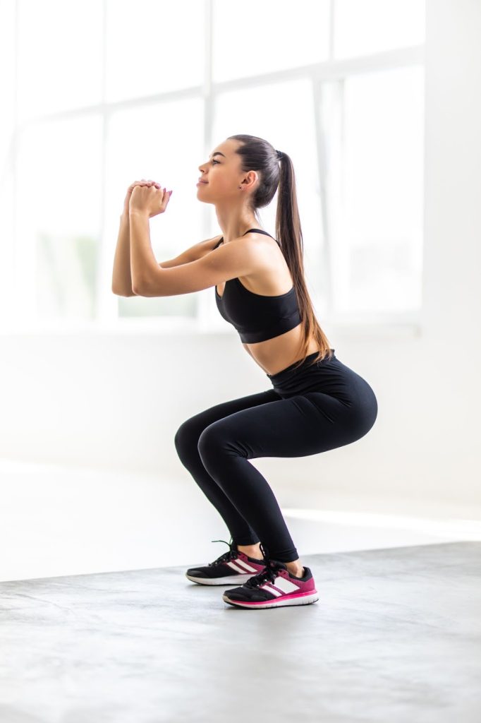 squat dengan jangkauan mengetatkan otot perut dan lengan